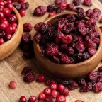 Пресни и сушени червени боровинки в дървени купи