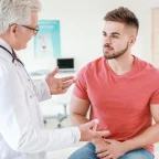 Млад мъж разговаря с лекар уролог за увеличена простата в лекарски кабинет