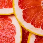 Близък план на нарязани резени червен грейпфрут с наситен цвят и сочна текстура – източник на витамин C и антиоксиданти