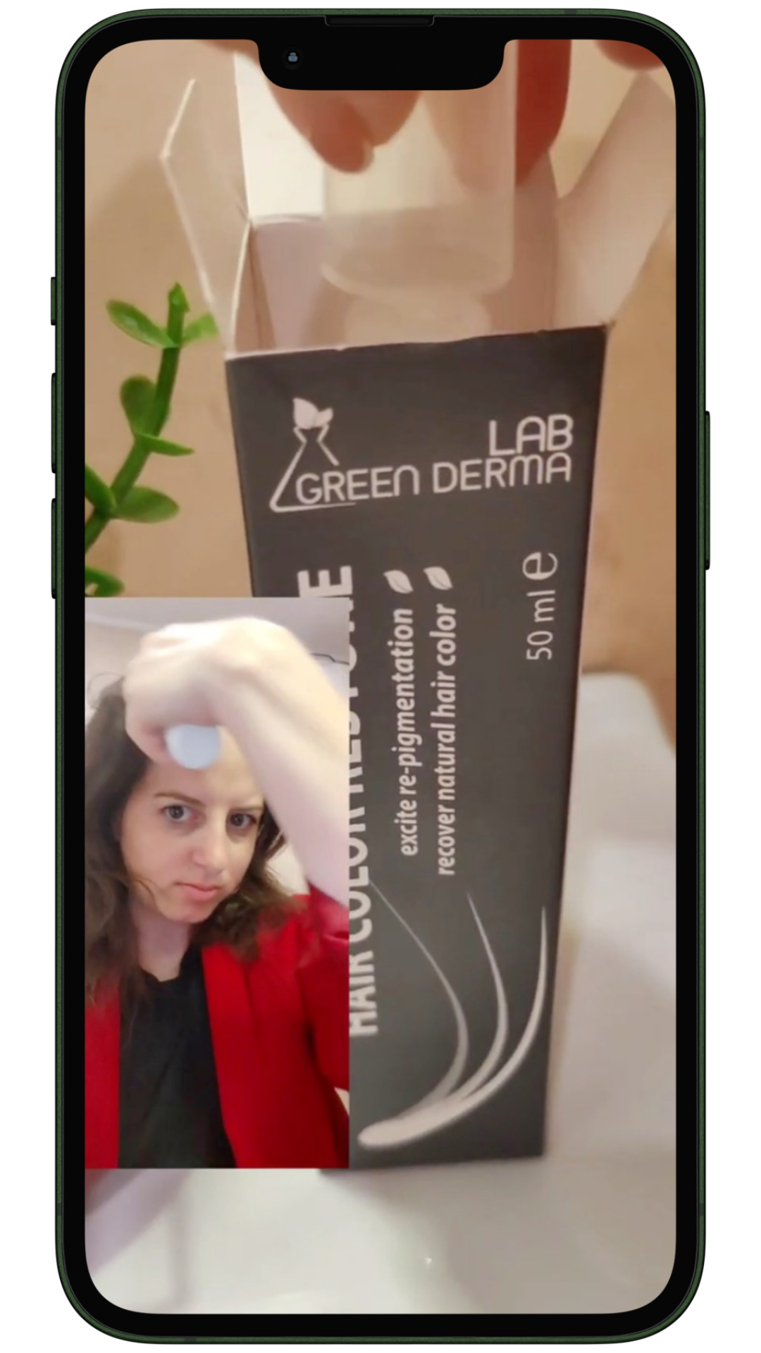 Жена с бели корени нанася Hair Color Restore спрей и показва опаковката пред камерата – реално ревю за възстановяване на естествения цвят на косата с Greyverse™